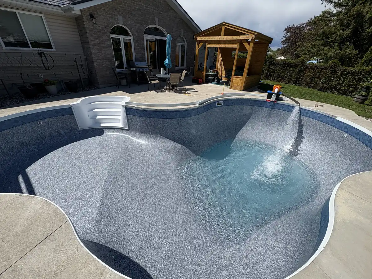 Kidney pool with a light grey liner filling with water