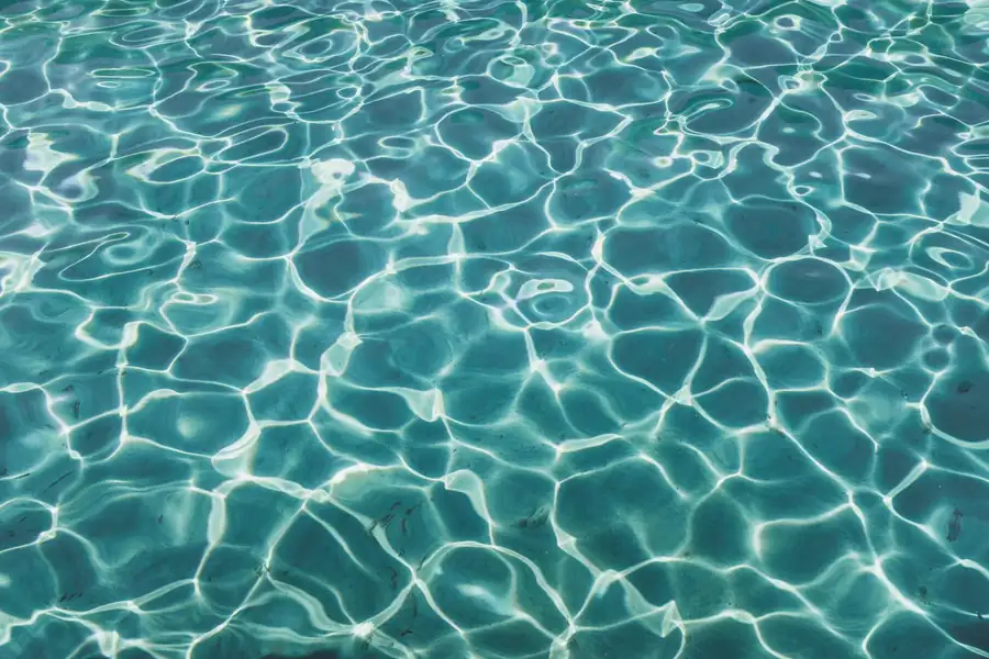 Sunlight ripples across a blue vinyl pool liner